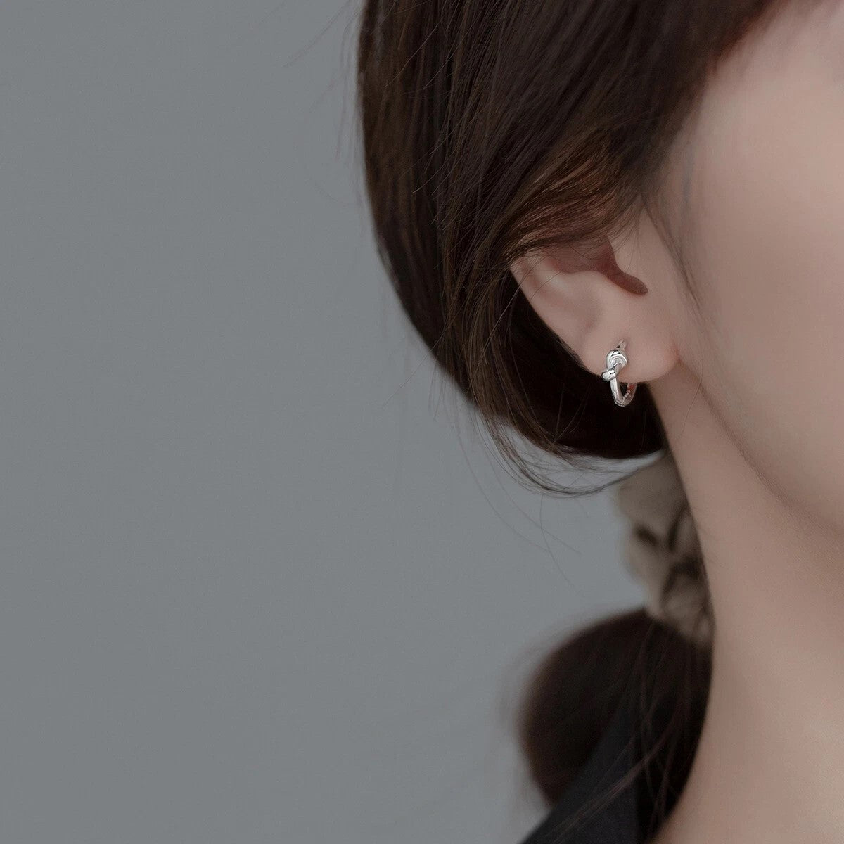 Twisted Knot Mini Hoops in rhodium-plated silver offer a timeless shine, anti-tarnish durability, and everyday elegance with a modern, sculptural twist.